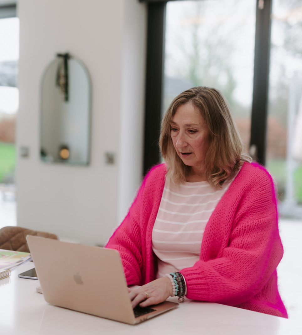 Elizabeth James smiling while writing in her notebook, offering calm private WhatsApp mentoring for baby class teachers