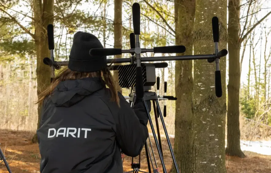Woman adjusting an acoustic technology sensor mounted on a tripod