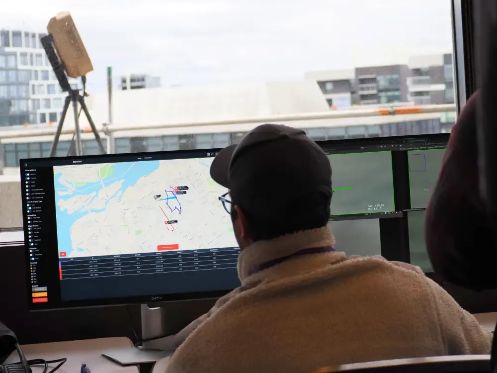 An operator in front of a computer displaying a command-and-control user interface for counter-drone operations.
