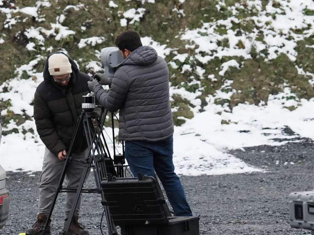 Two men installing counter-drone equipment