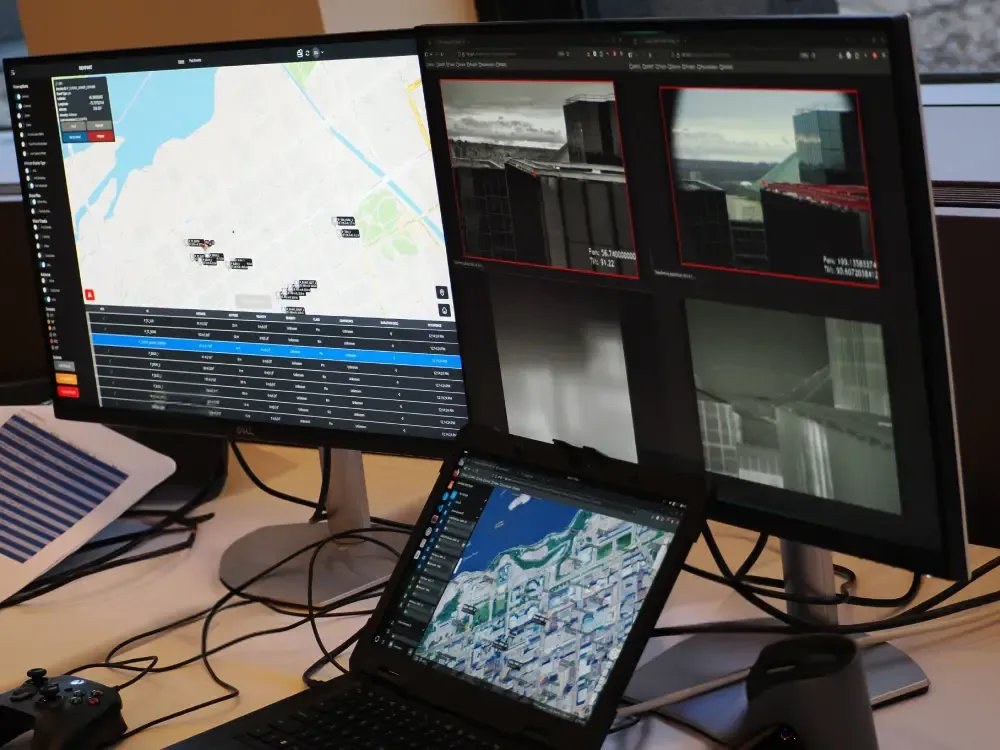 Three computers showing a command-and-control interface for counter-drone operations