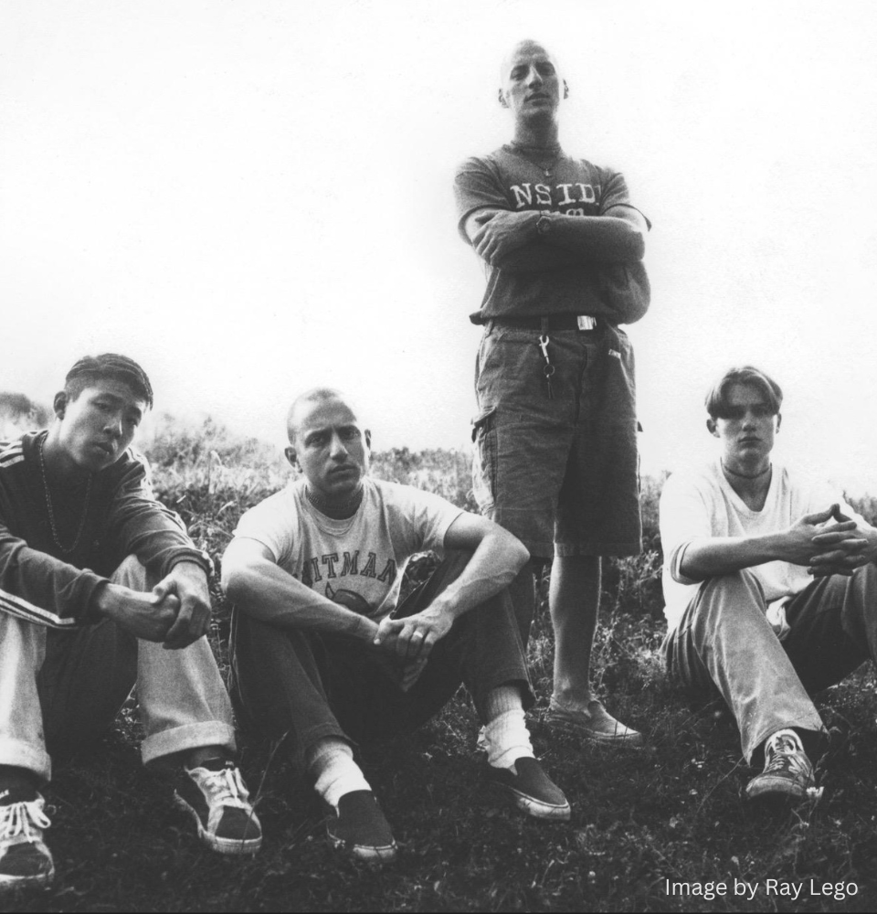 Black and white photo of Ray “Raghunath” Cappo with members of Youth of Today, early hardcore punk band, seated outdoors representing the straight edge movement and punk subculture