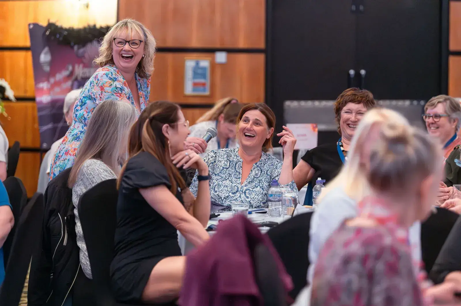 Women laughing together around a table at The Connection 2026