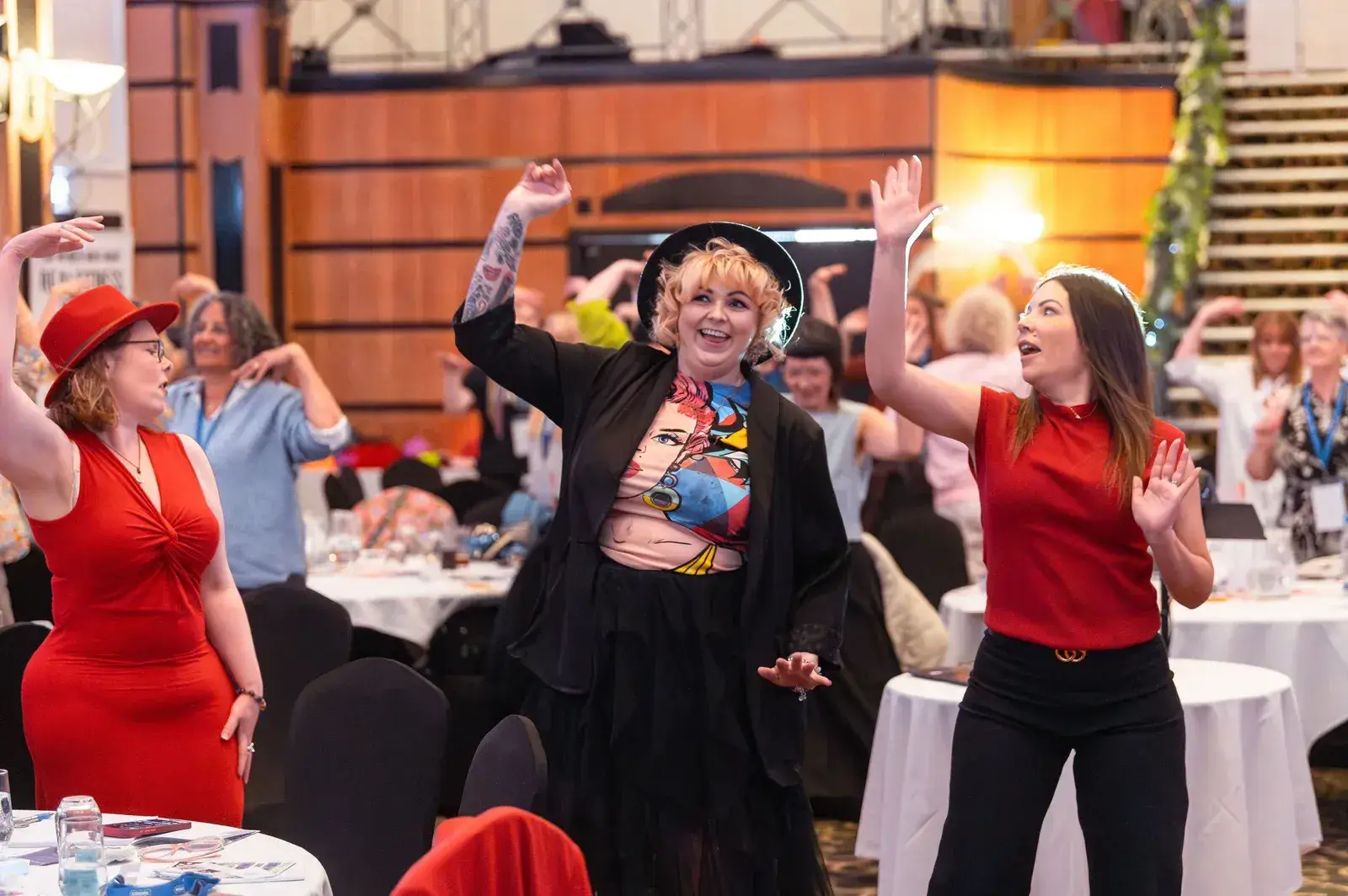 Women dancing and raising their hands at The Connection