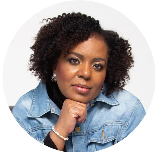 Professional headshot of Kisha Johnson, Treasurer of Colorado Business Women (CBW), smiling against a dark gray background while wearing a black blazer over a bright pink blouse.