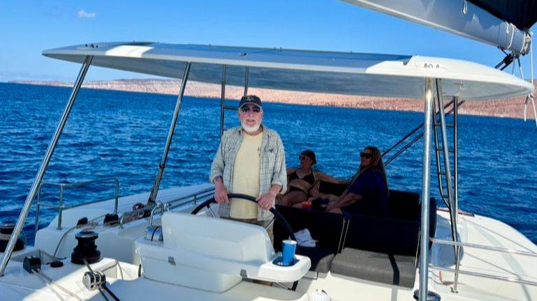 Older gentleman sailing catamaran in Mexico