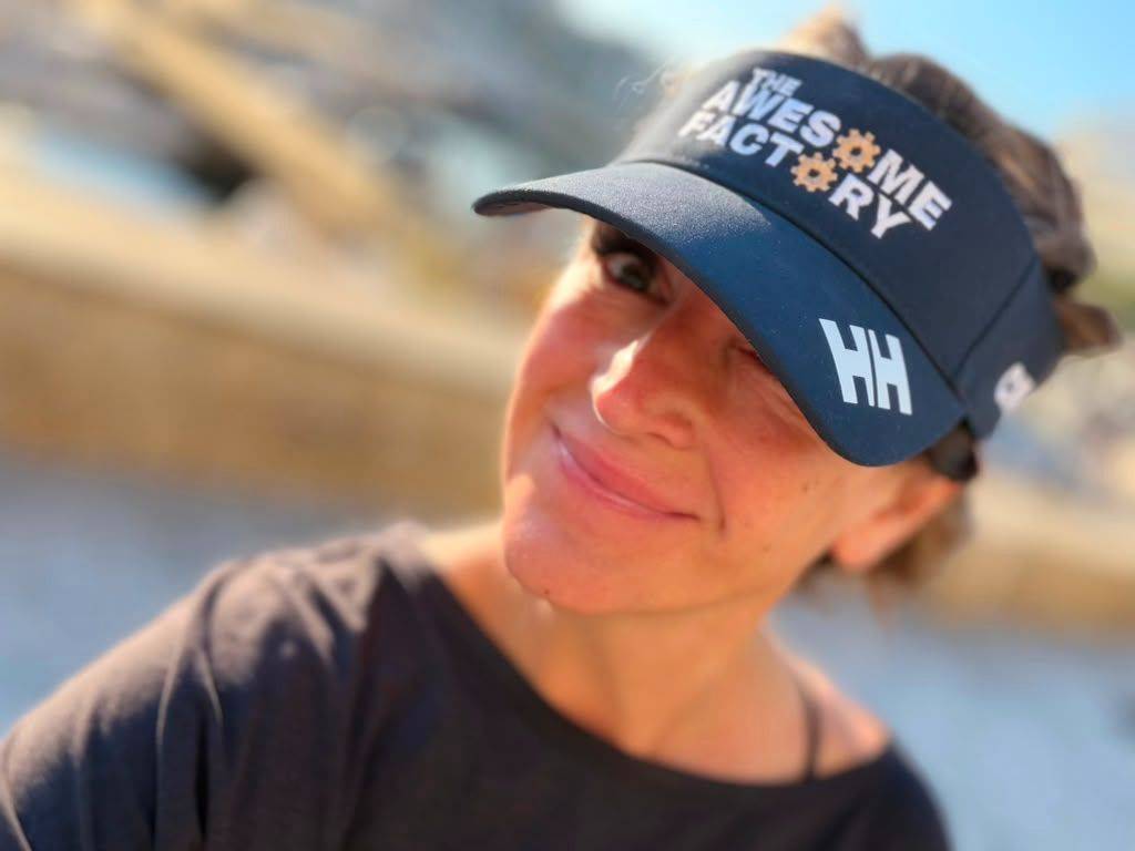 Solo female traveler wearing Awesome Factory sun visor in Greece