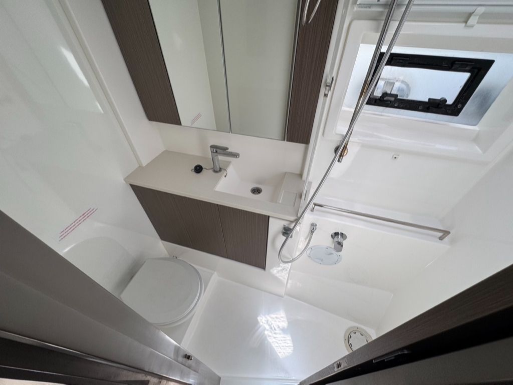 Bathroom with a toilet, vanity, and shower