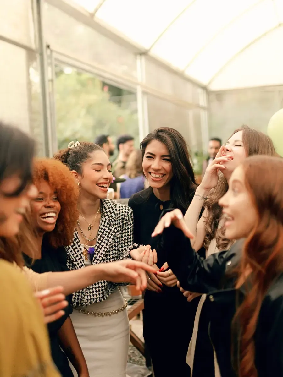 Group of women laughing and connecting at a live workshop, representing the supportive community space created in the Your Relationship with YOU workshop with Laura Rochelle