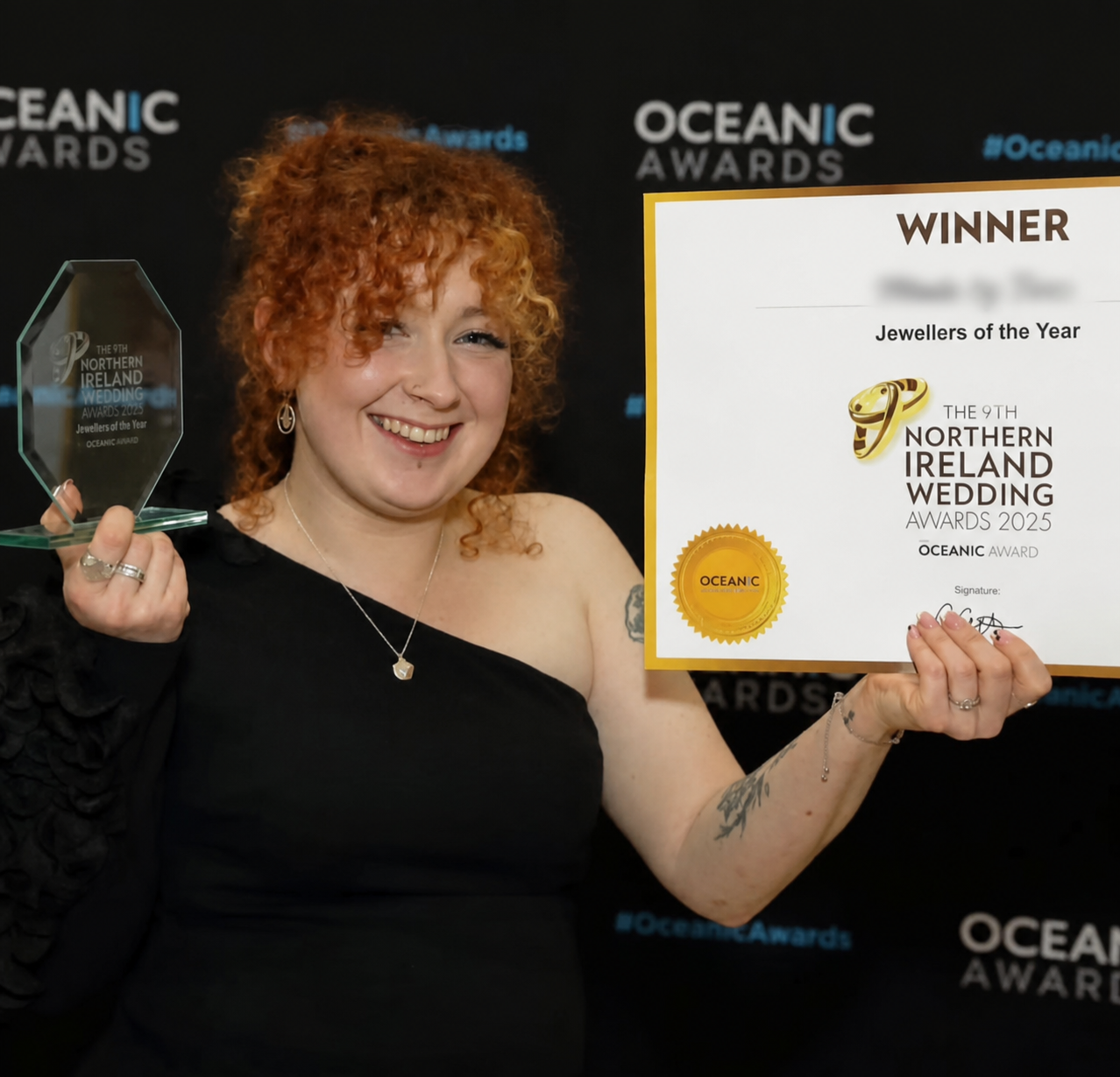 Award-winning jeweller Tara holding her award and certificate