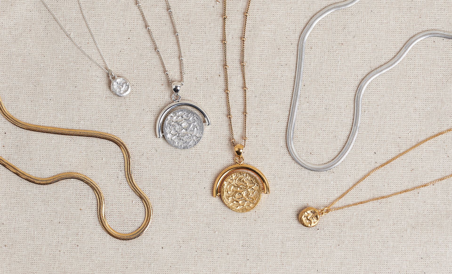 A curated flat lay of gold and silver Megan Collins necklaces