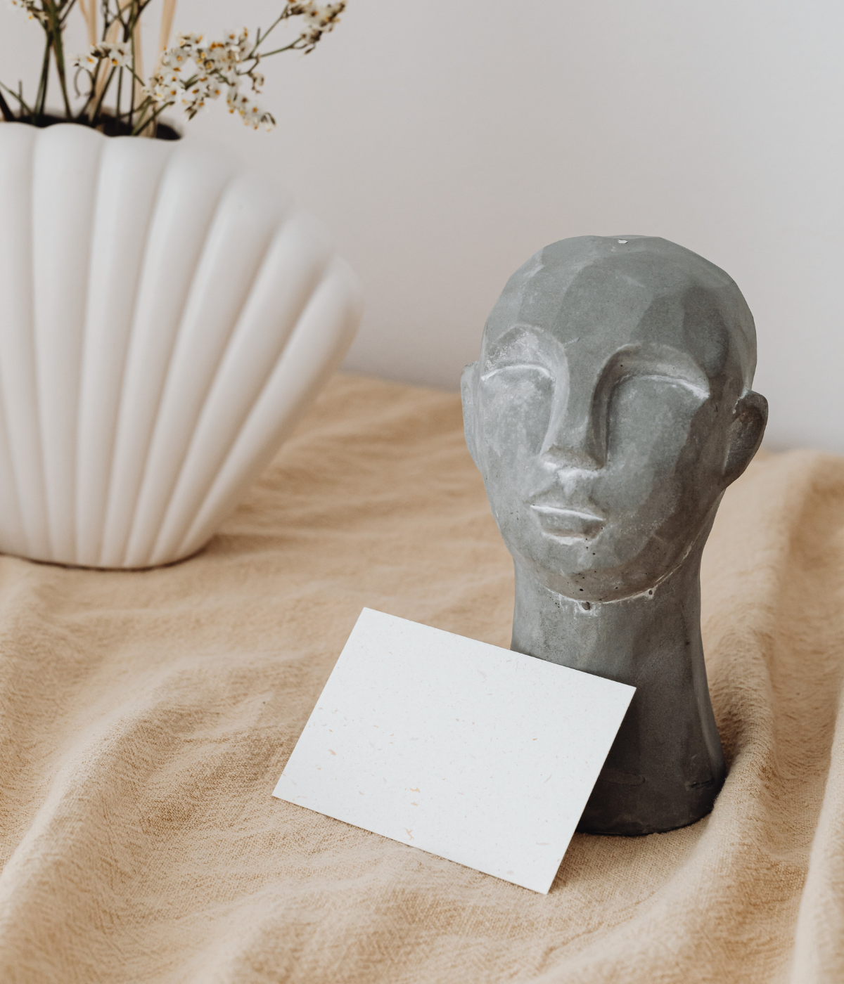 sculpture of a head with a blank postcard in front of it