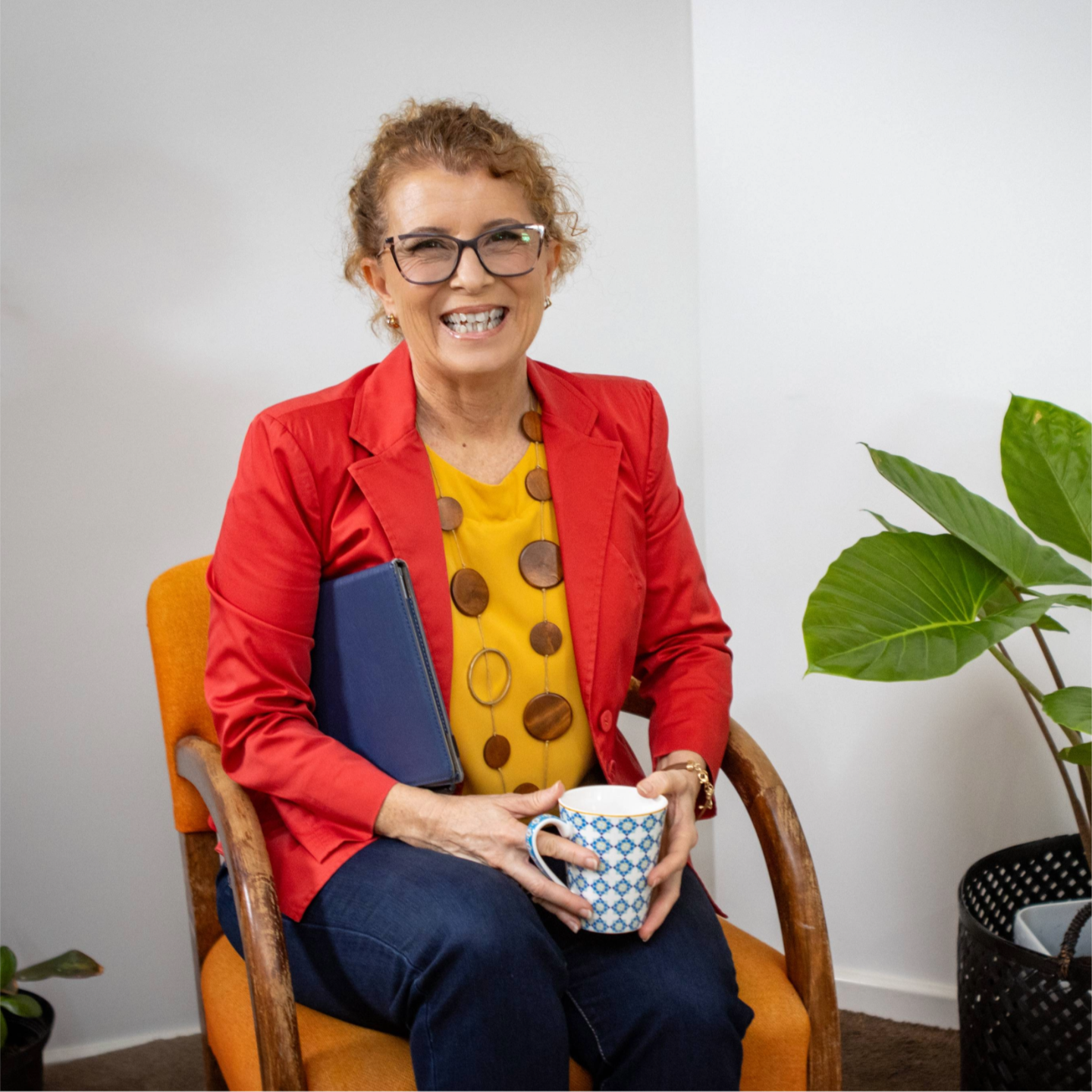 Cherelle Witney smiling while sitting in chair holding tea cup