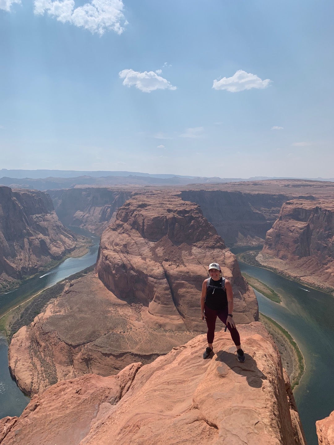 Chelsey standing on the rim at Horseshoe Bend