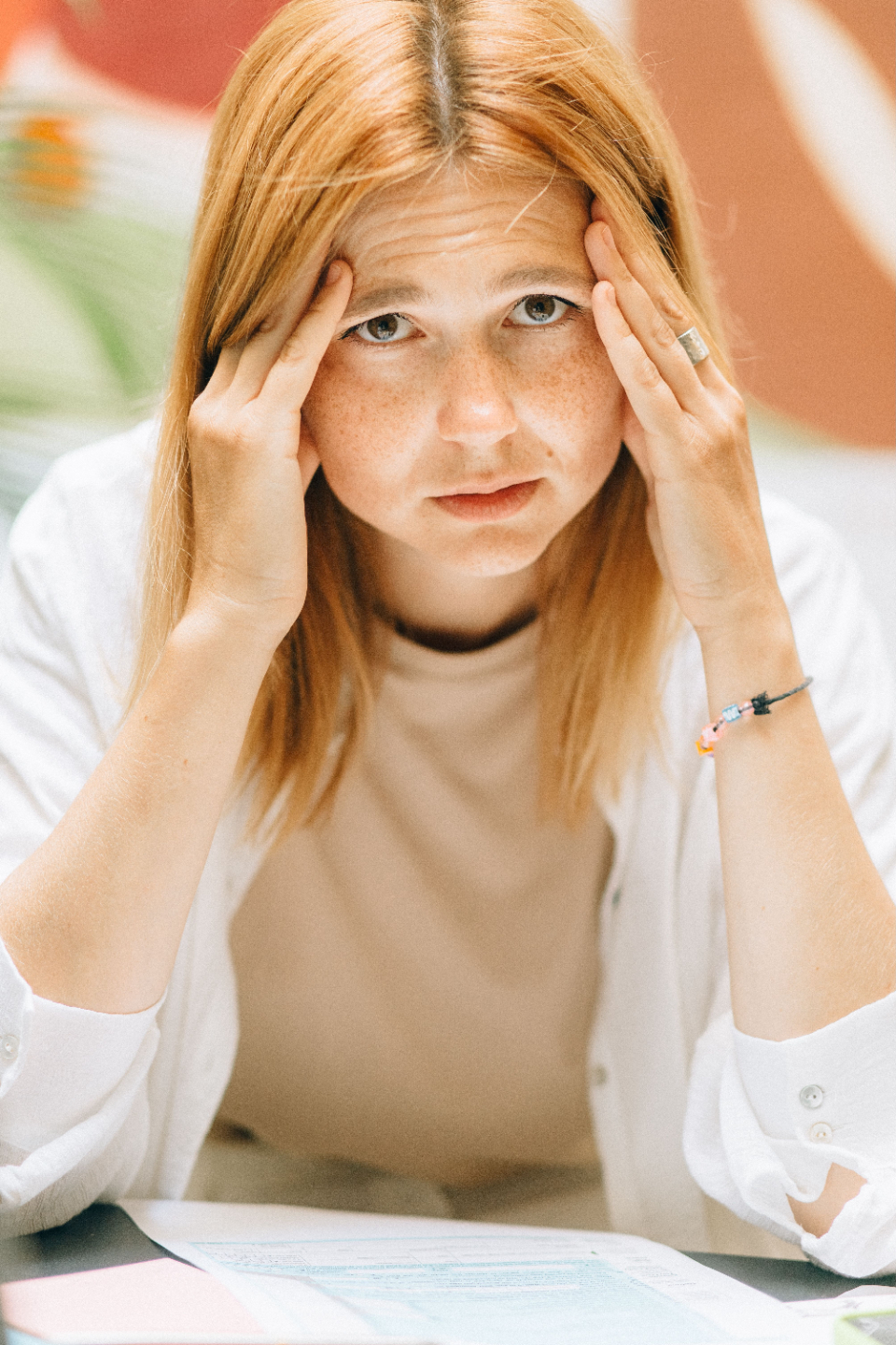 Young woman puts her hands on her head in frustration.