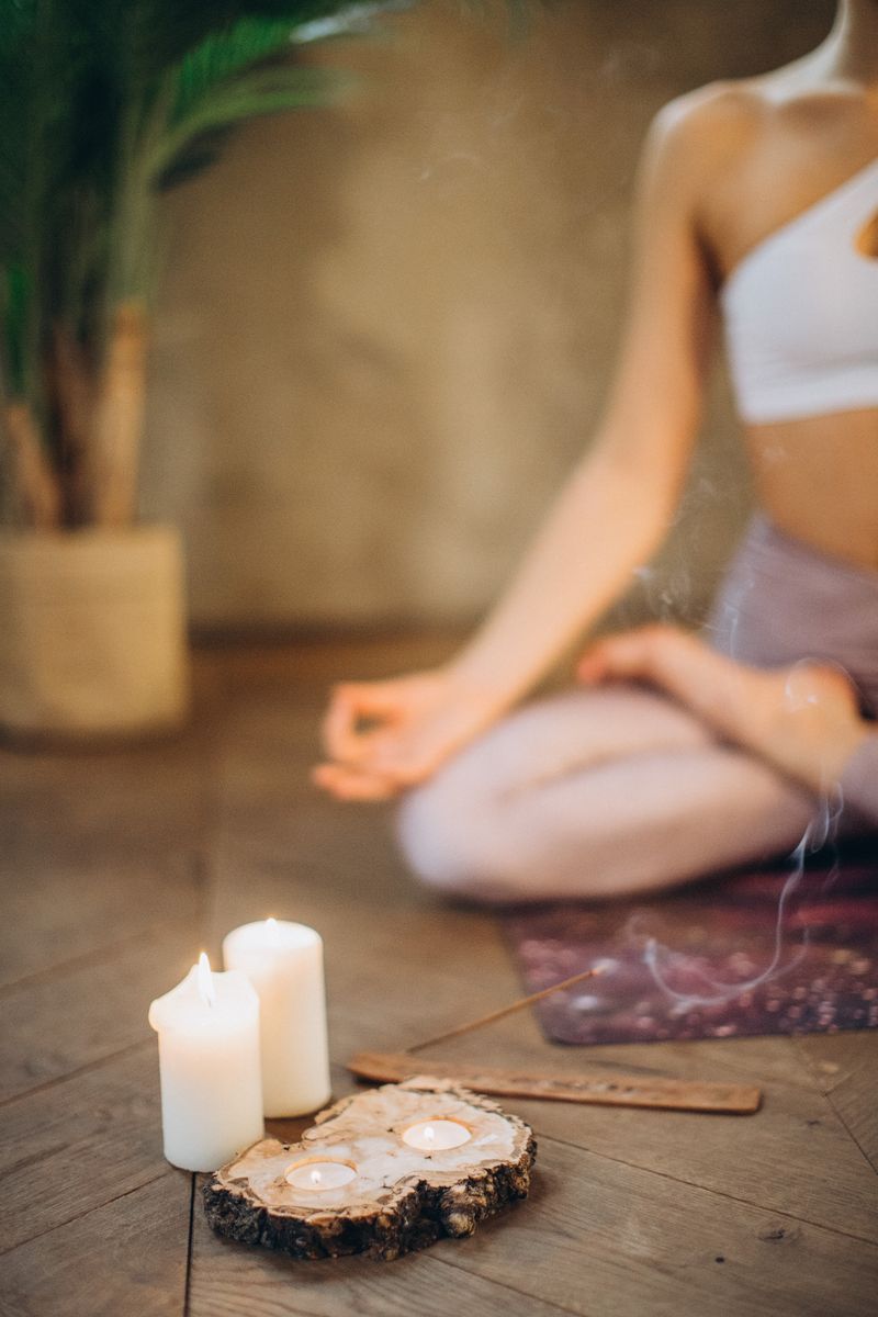 Woman meditating with candles and incense.