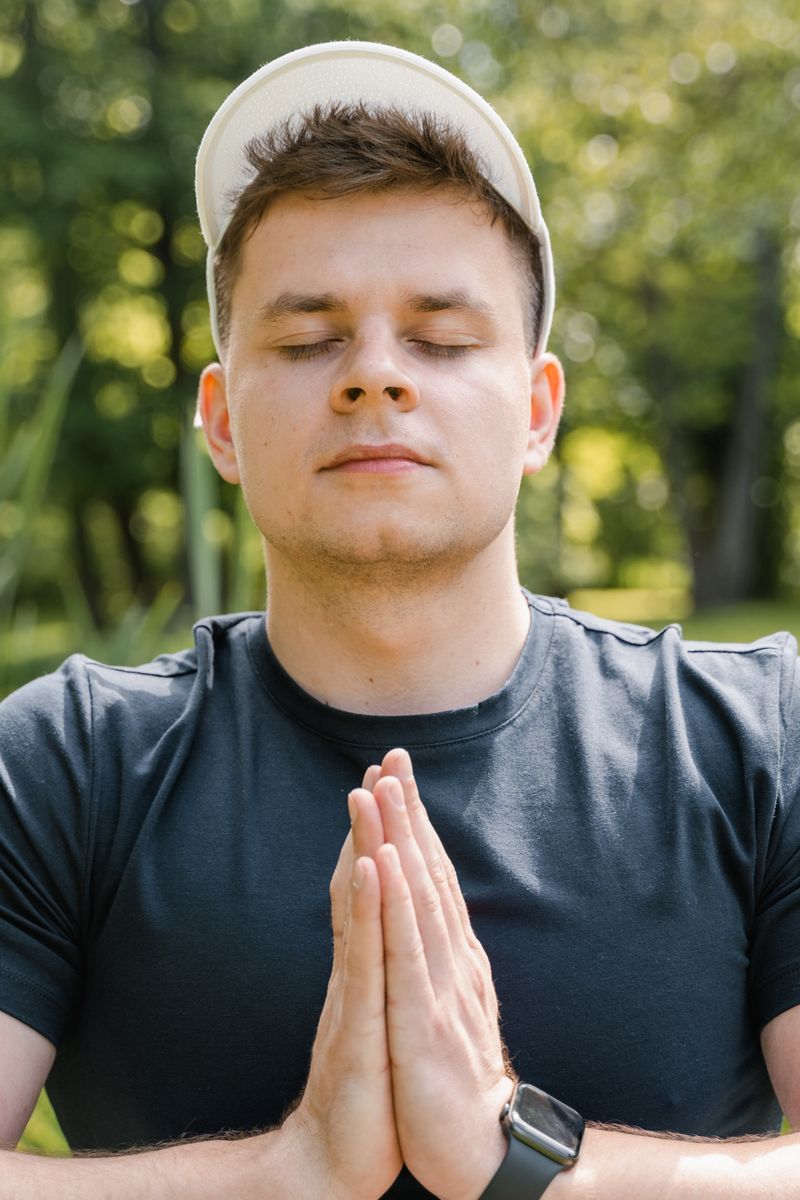Man meditates peacefully in the park.