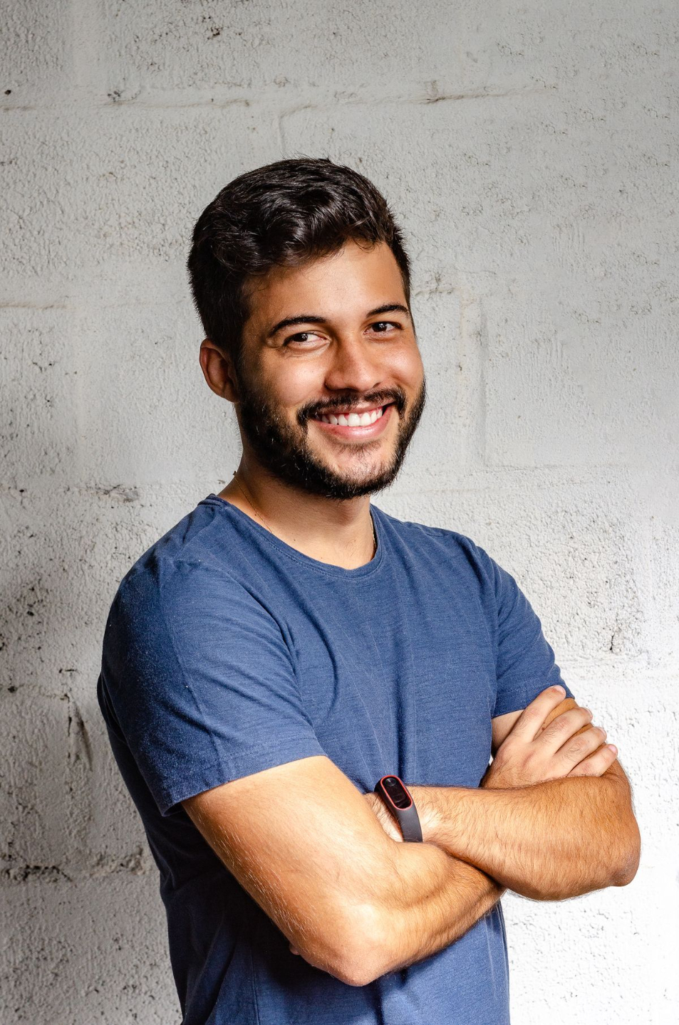 Man smiles while crossing his arms.
