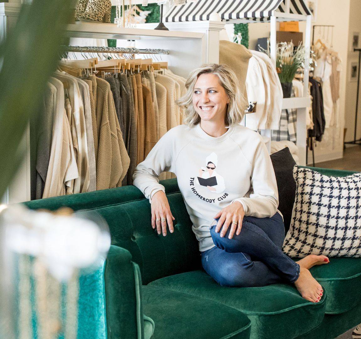Ciara Stockeland sitting on green sofa in retail shop.