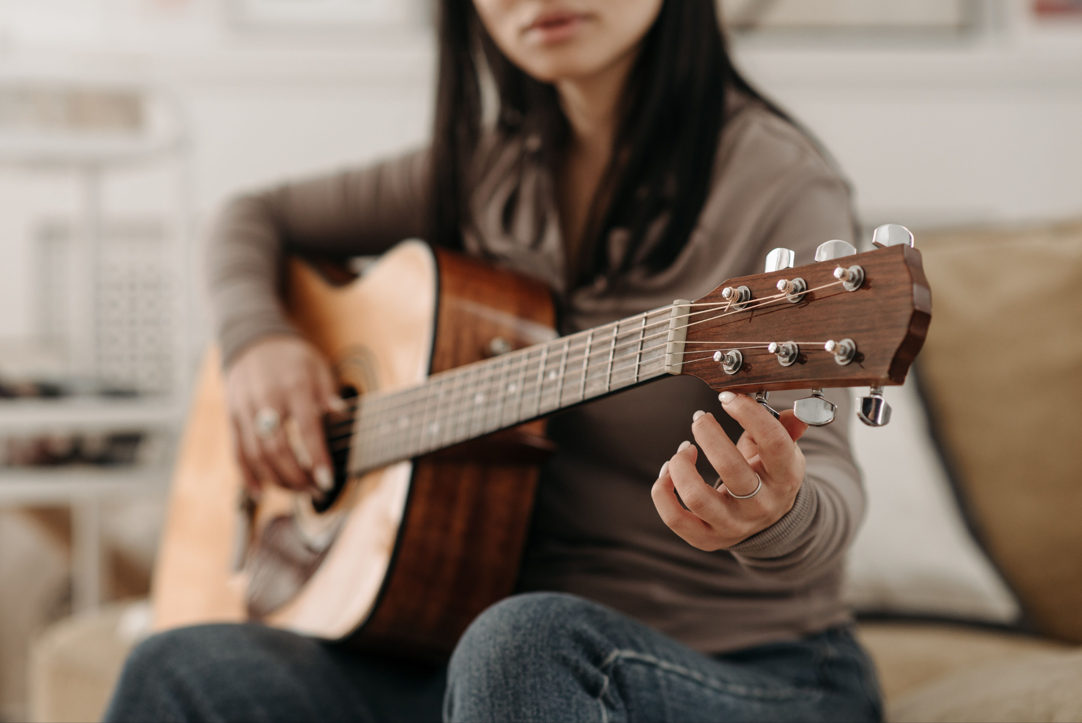 Woman plays guitar.