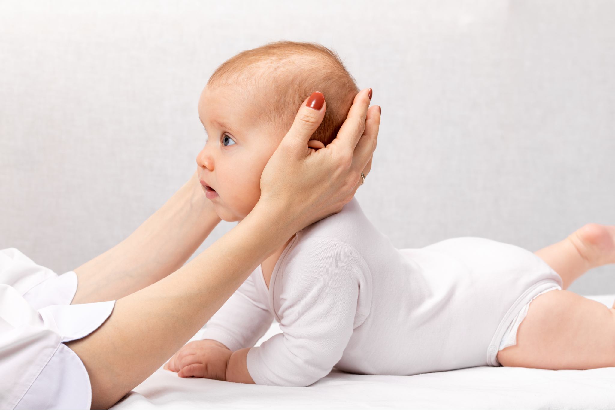 Baby doing tummy time to support neck strength, head control and baby flat head prevention.