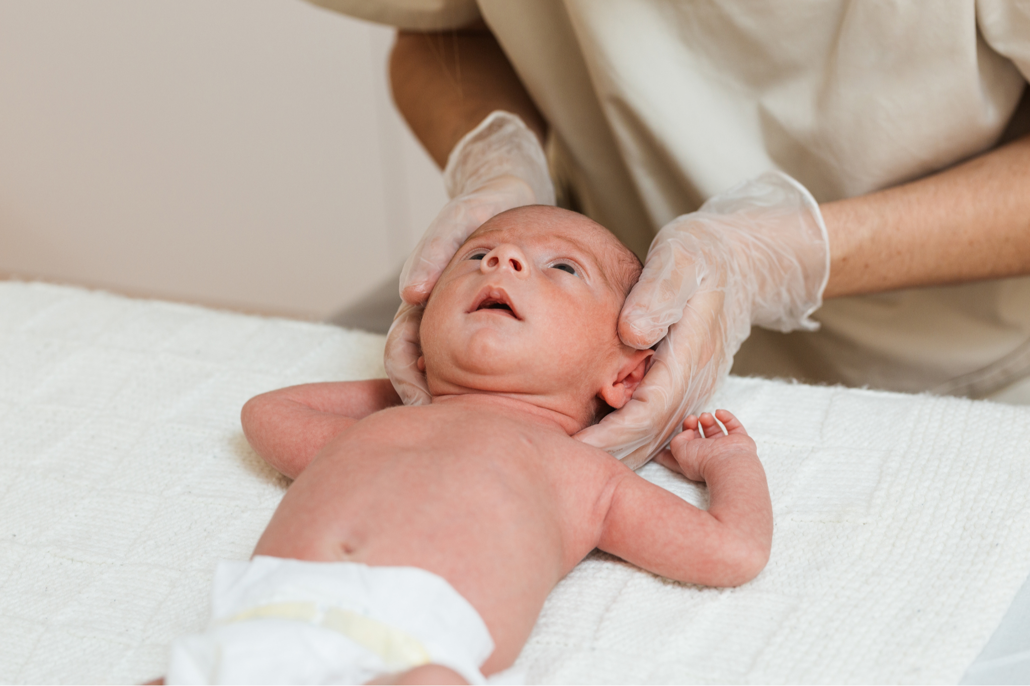 Newborn baby resting safely, highlighting early support for head shape, positioning and infant physiotherapy.