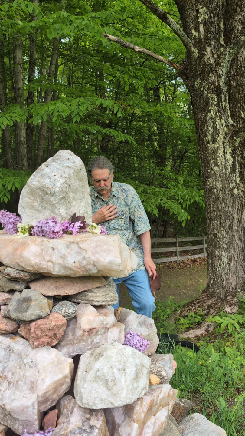 zacciah blackburn in devotional prayer besided a stone cairn