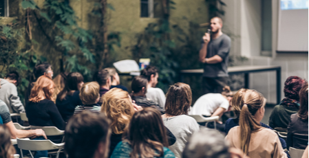 Man presenting to a room full of people