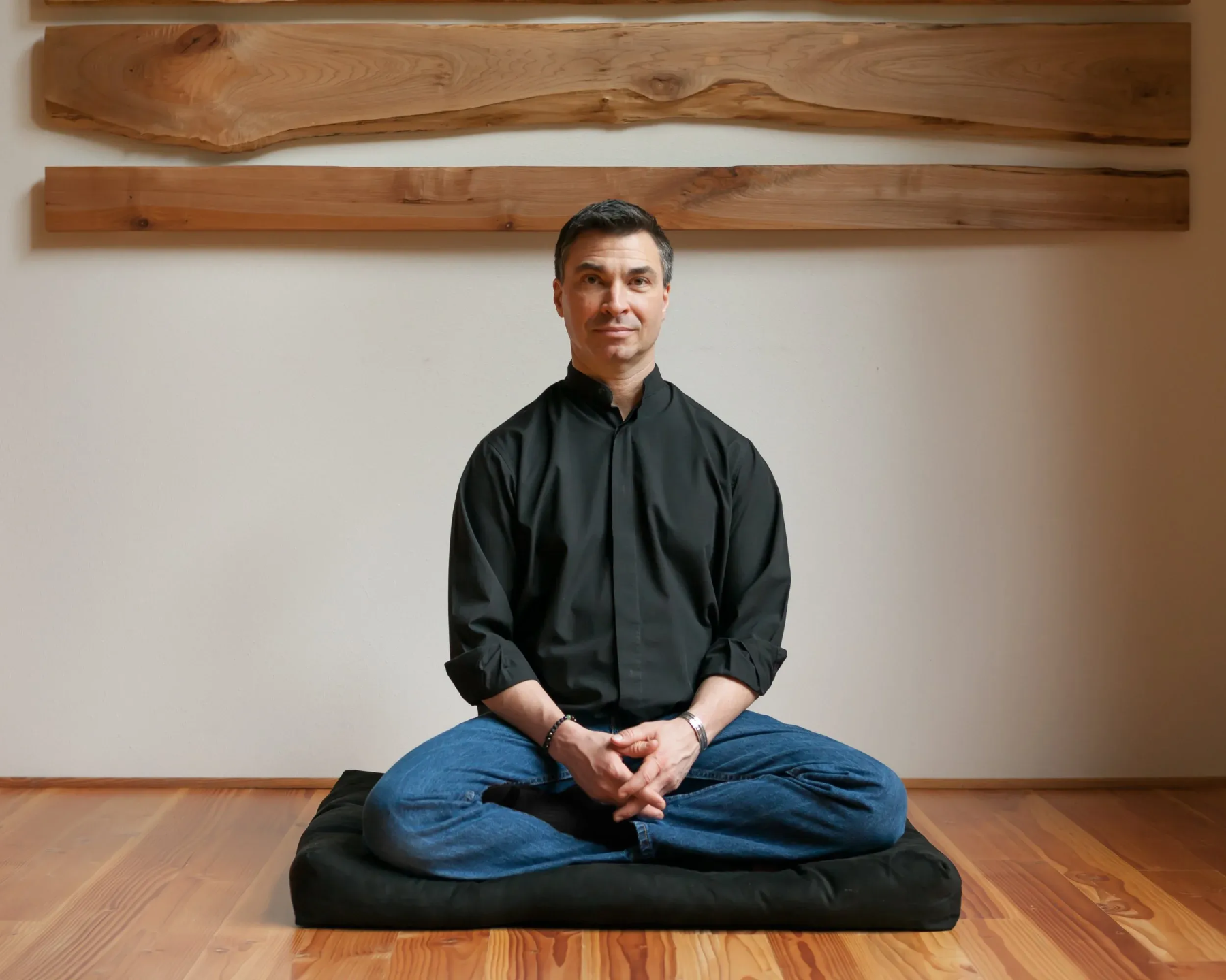 Neuroscientist, Dr. Jeffrey Tarrant sits peacefully on a meditation pillow.