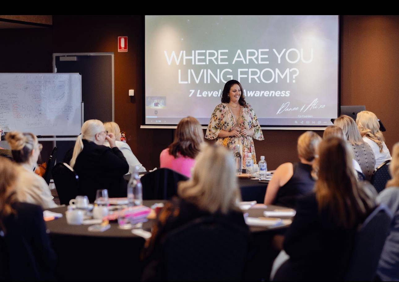 Danee speaking to a room of women at a live event