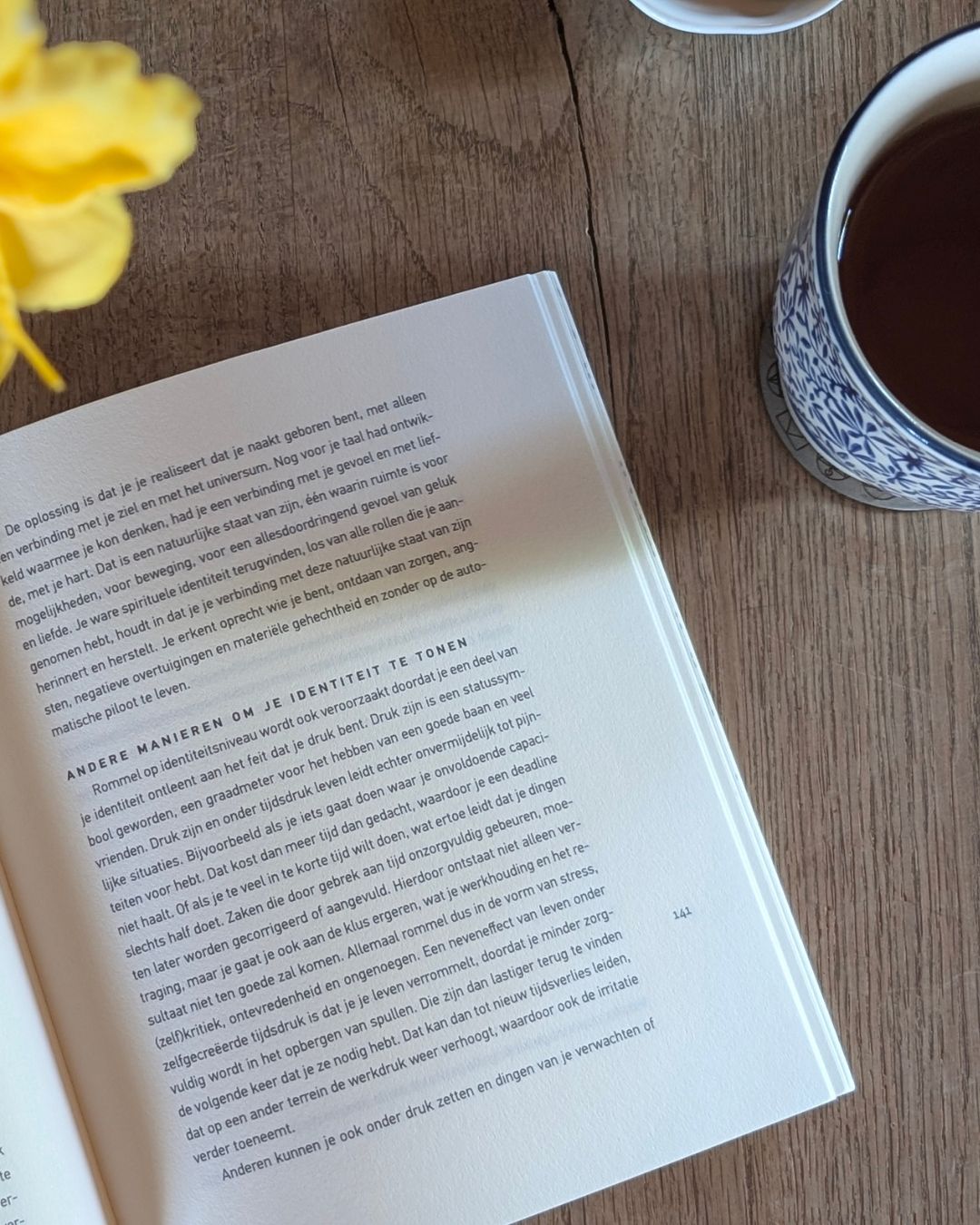 opengeslagen boek op tafel met een kop thee