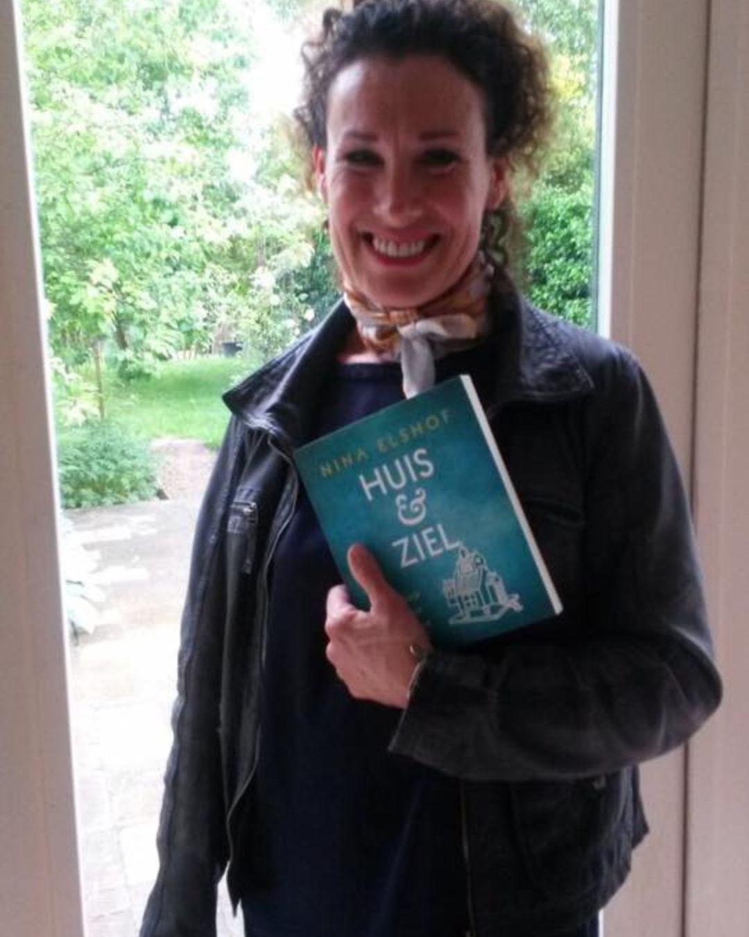 nina elshof poseerd met het boek Huis & Ziel voor een raam