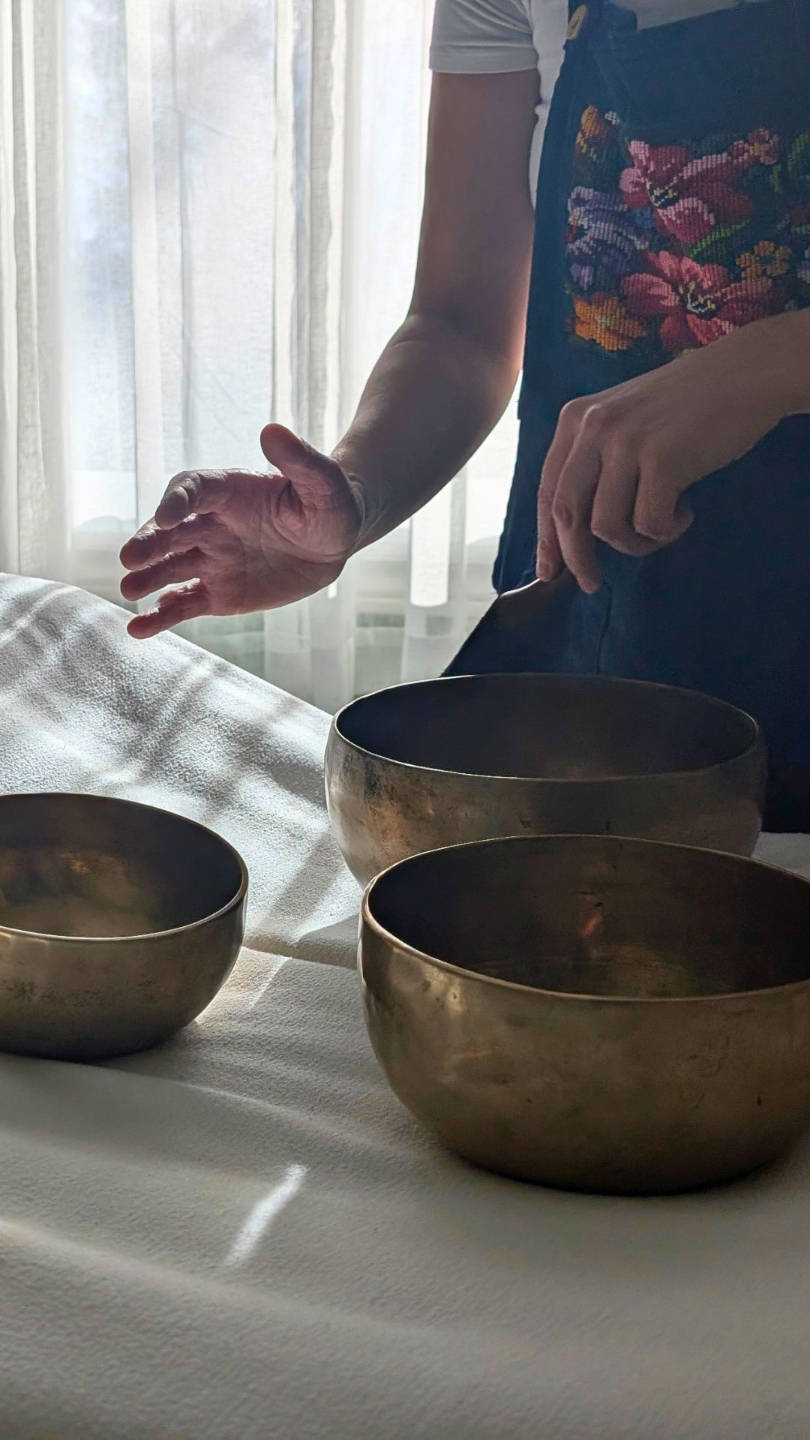 Person playing metal Himalayan singing bowls in a practice room