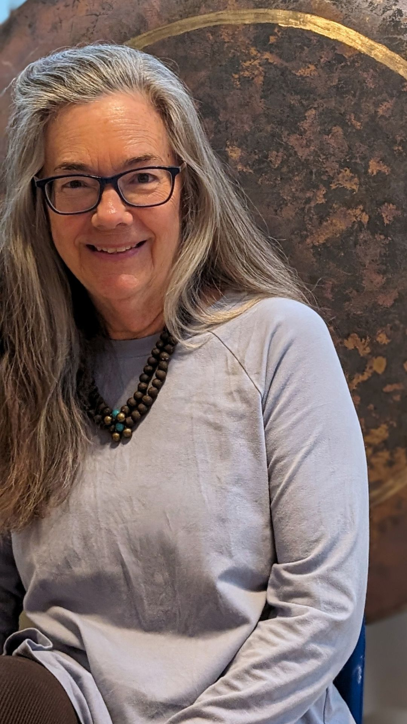 Dorothy Stone smiling in front of a gong
