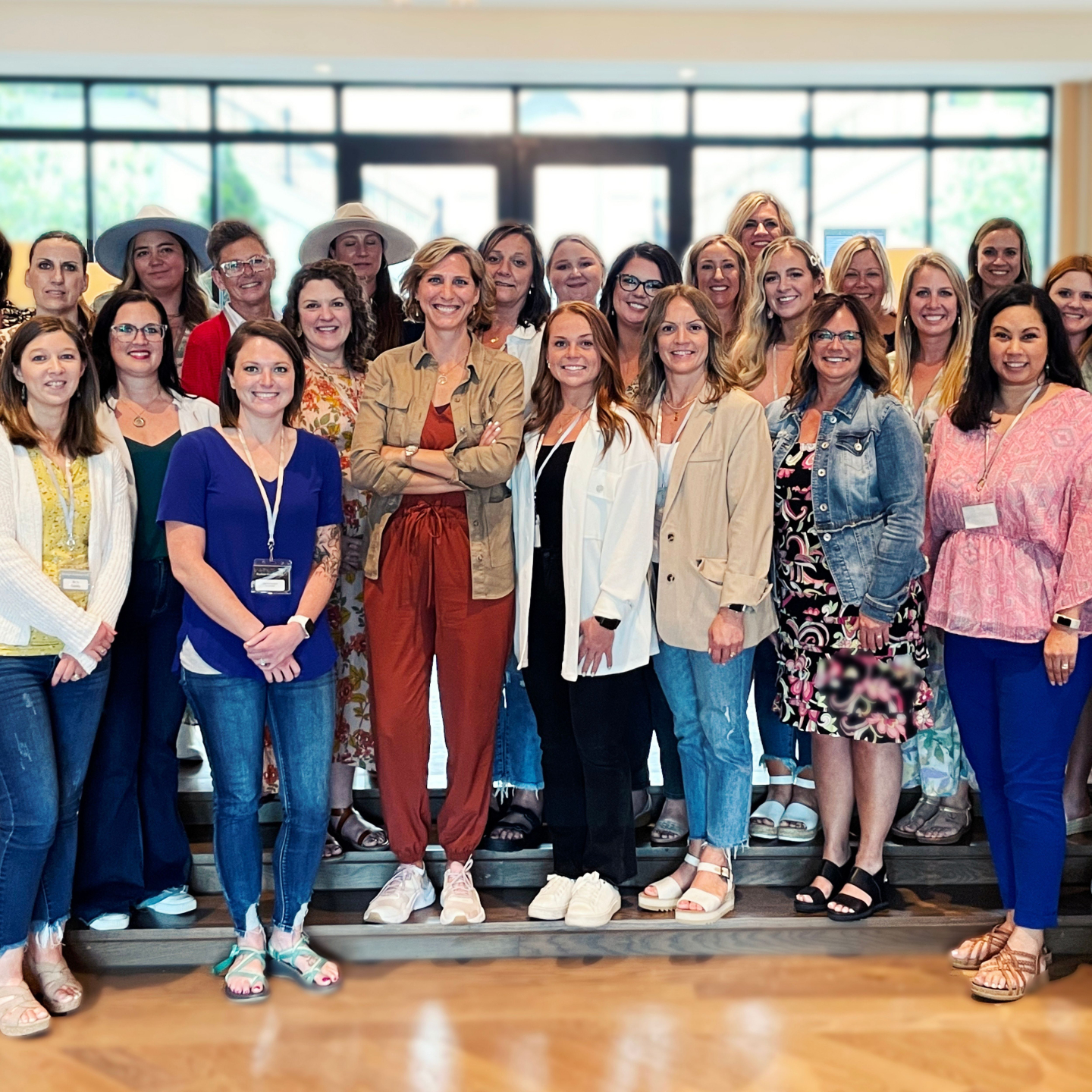 Ciara Stockeland standing on stairs with a large group of coaching clients.