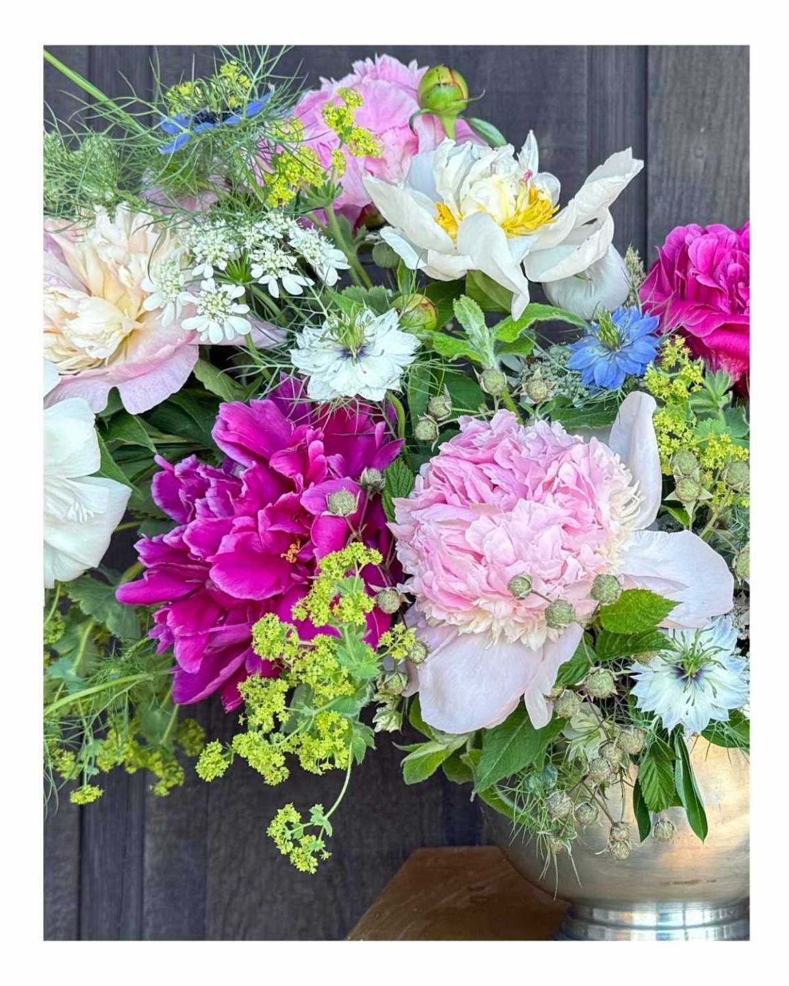flower arrangement with bupleurum, peonies, nigella - love in a mist, orlaya, and raspberries