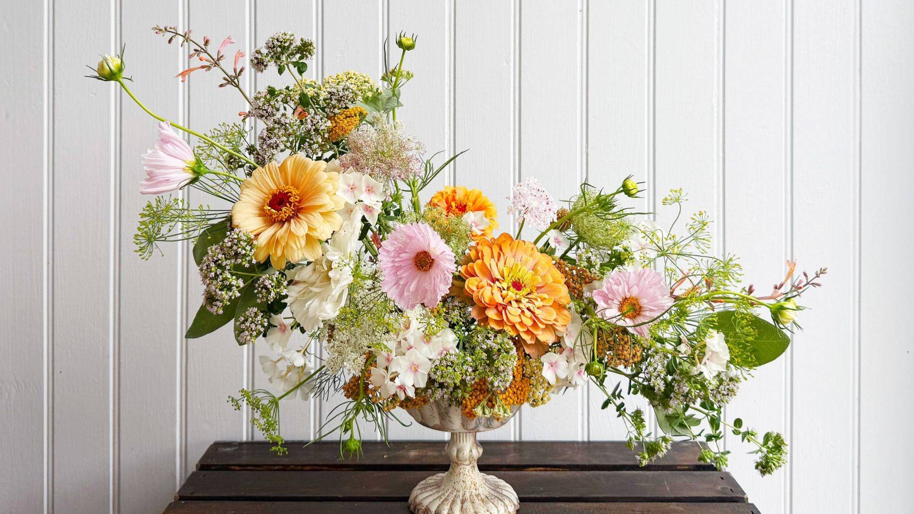 mercury glass compote with flower arrangement of zinnias, cosmos, yarrow, oregano, phlox, fennel and more