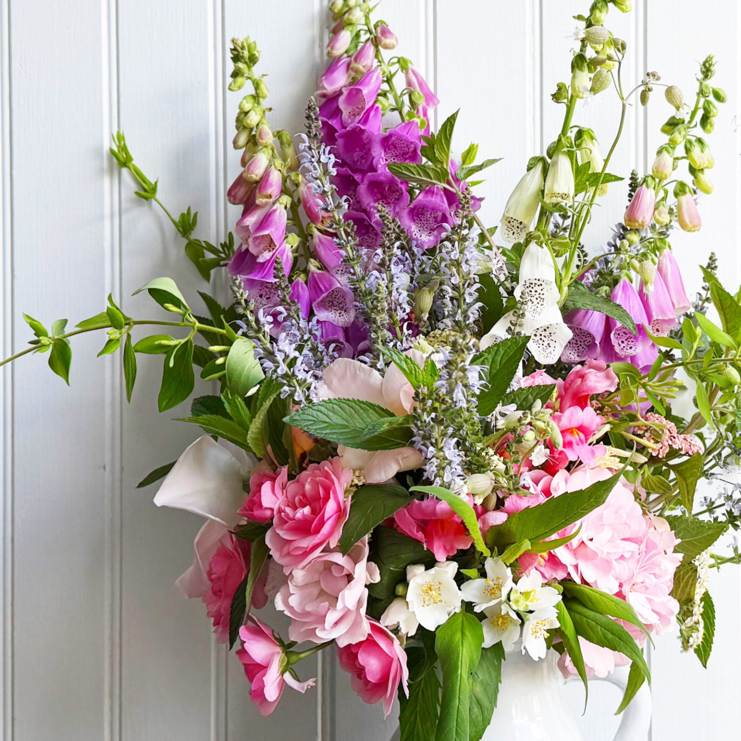 arrangement with foxgloves, roses and mint