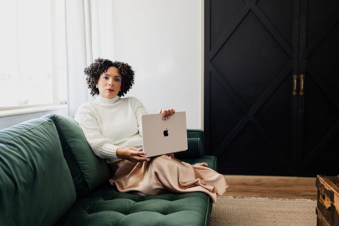 Yamel Belen using a laptop while seated at home.