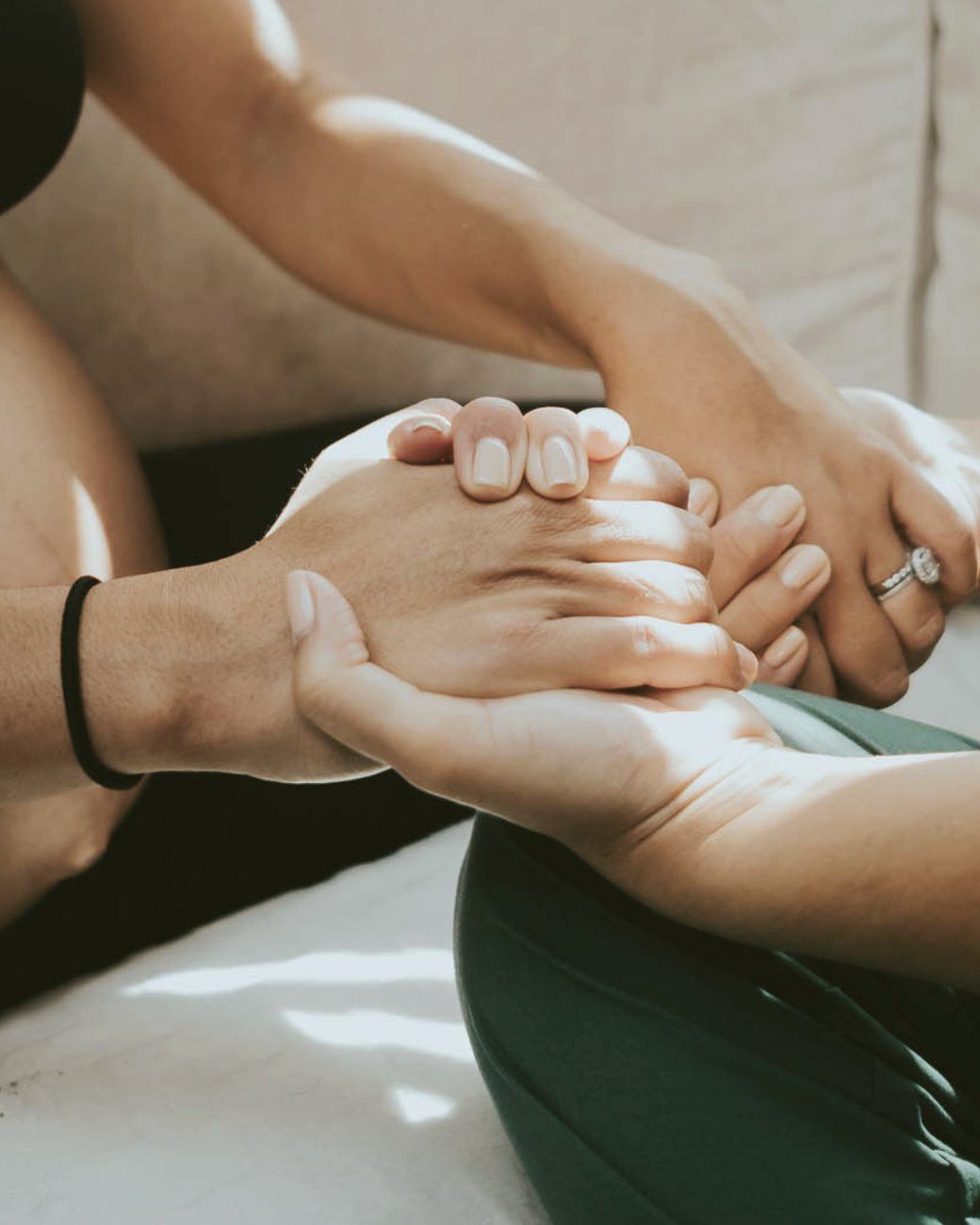 Birth partners holding hands in support during labor preparation.