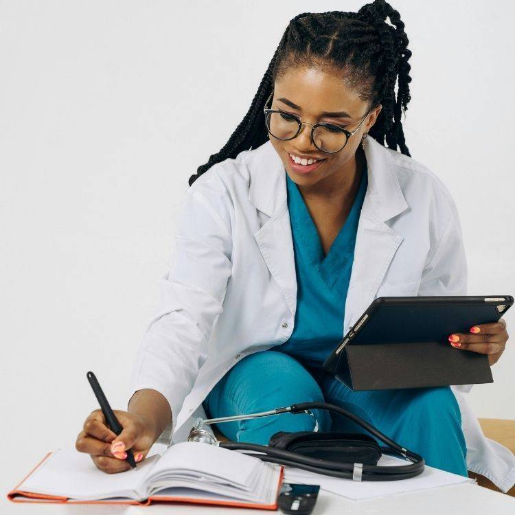 Happy female nurse hand writing notes