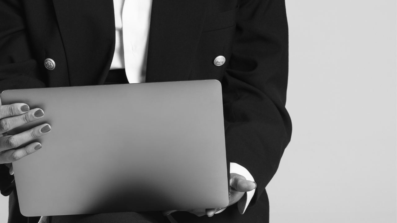 Holding a laptop during a reflective work session.