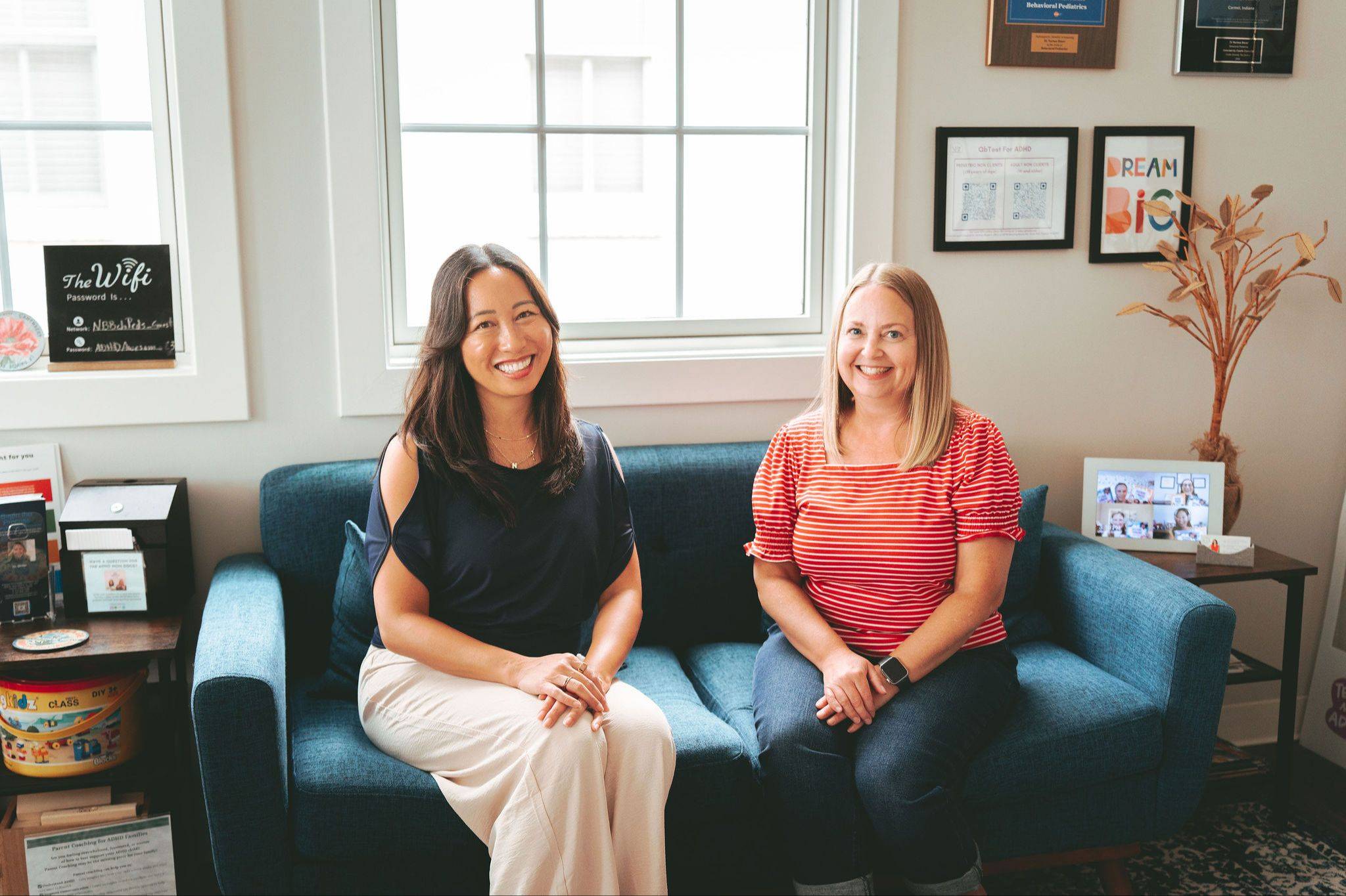 Dr Nerissa Bauer and Amy Barnes are sitting on a blue couch.