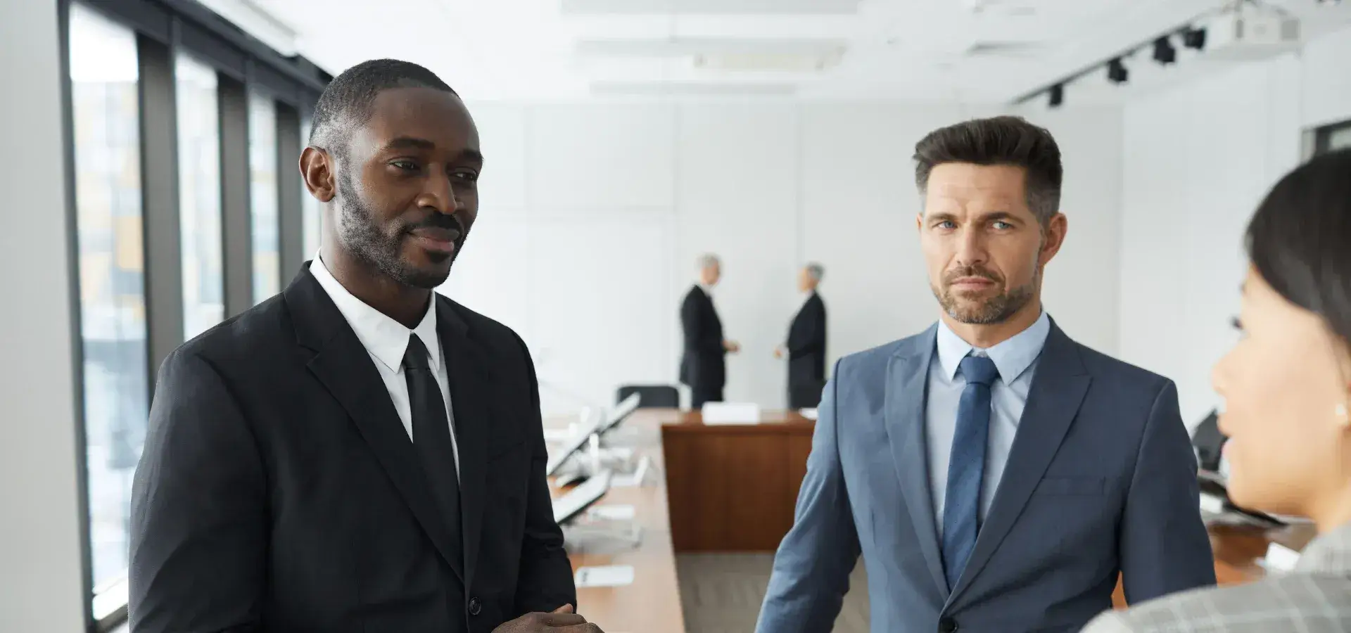 Black male lawyer speaking with colleagues in a modern office setting during a workplace conversation