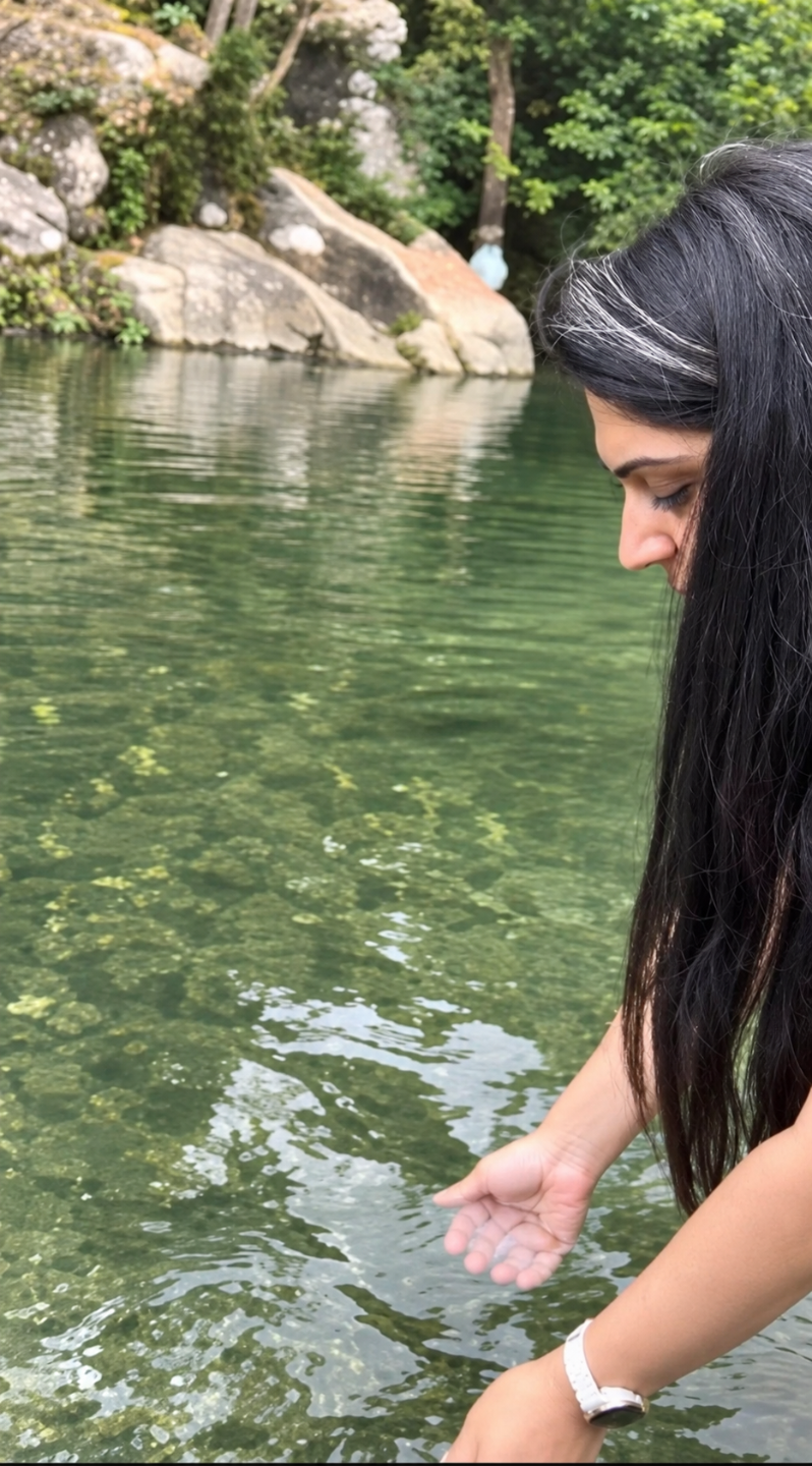 Shreya in a quiet contemplative moment beside a peaceful pond