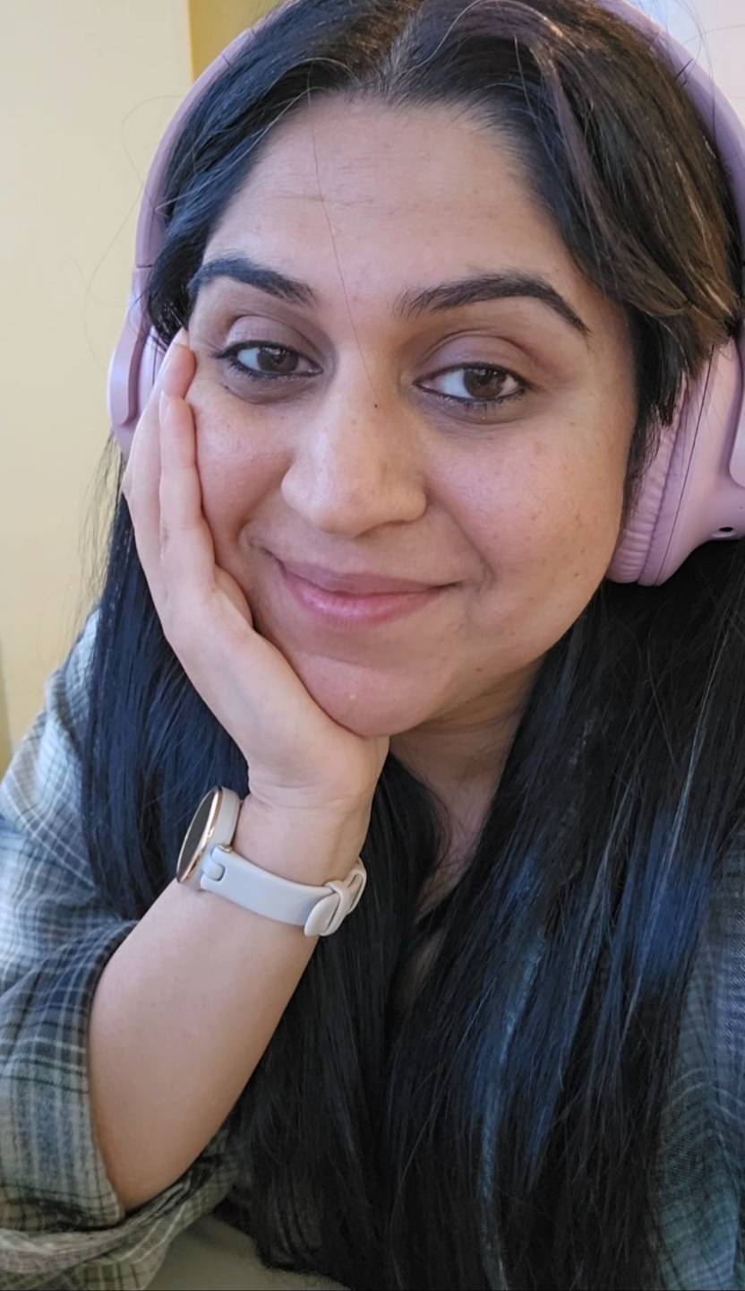 Shreya smiling warmly and wearing pink headphones