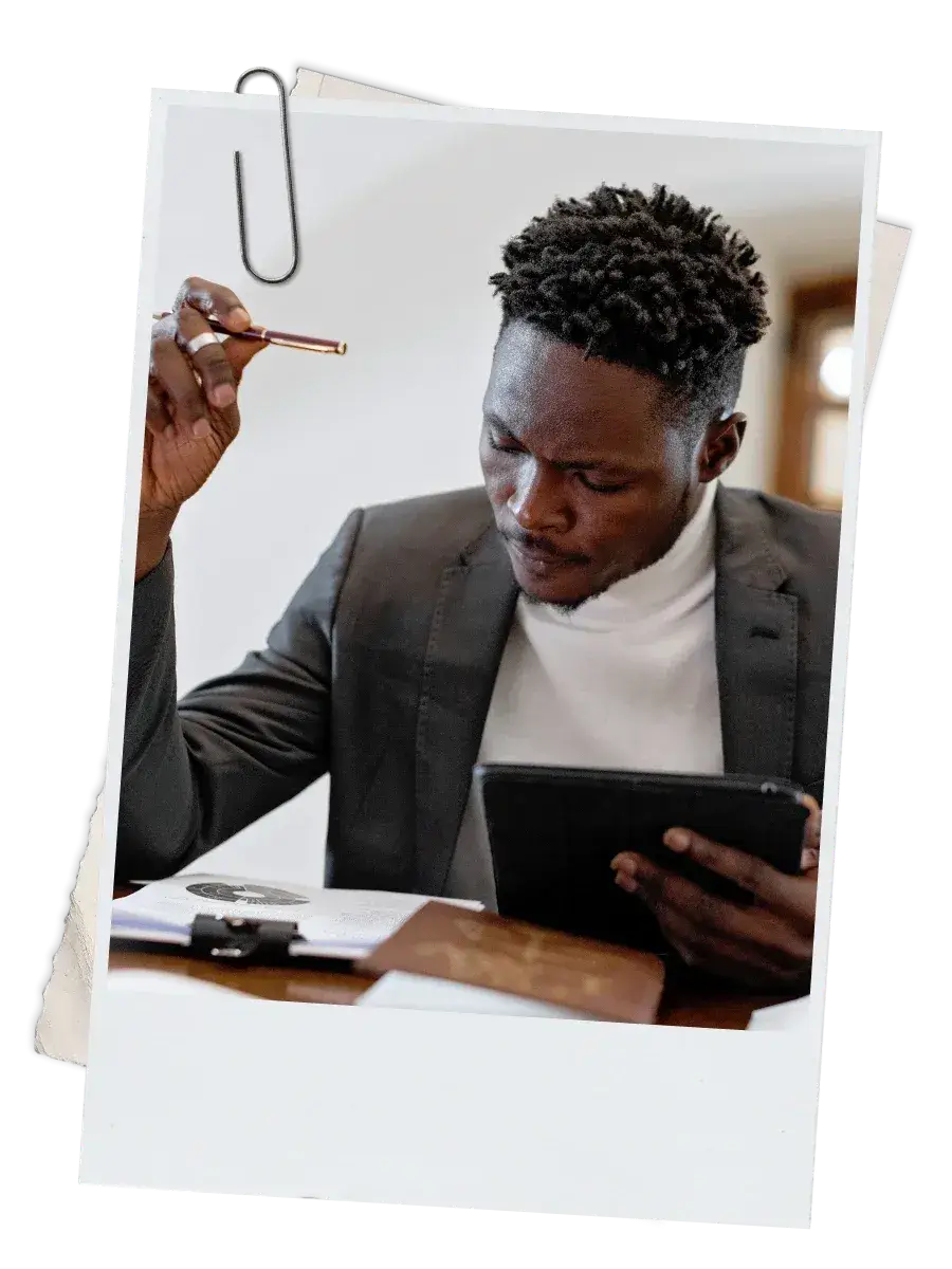 Black male lawyer reflecting thoughtfully while reviewing notes at his desk