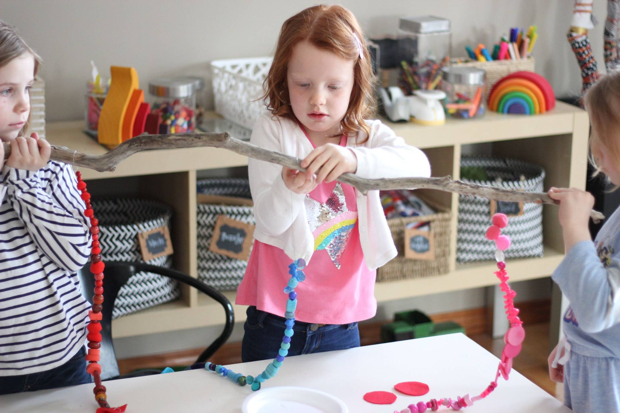 Children collaborating on a handmade rainbow mobile