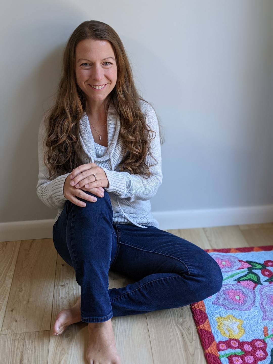 June Link sitting on the floor at home, relaxed and smiling