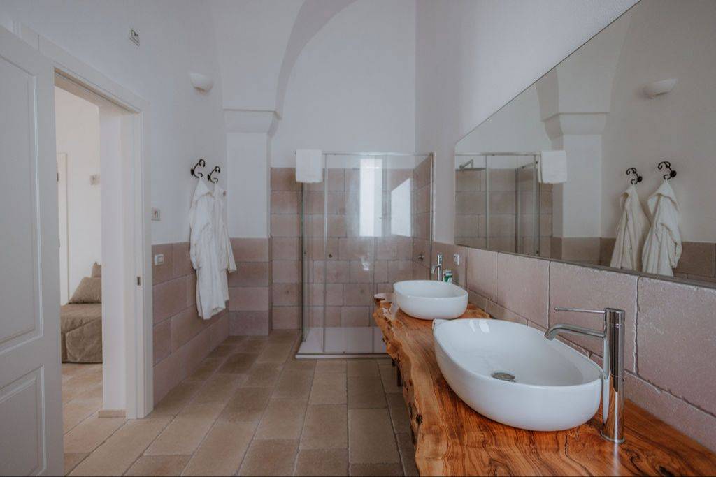 Badezimmer mit Glasdusche und Doppelwaschtisch